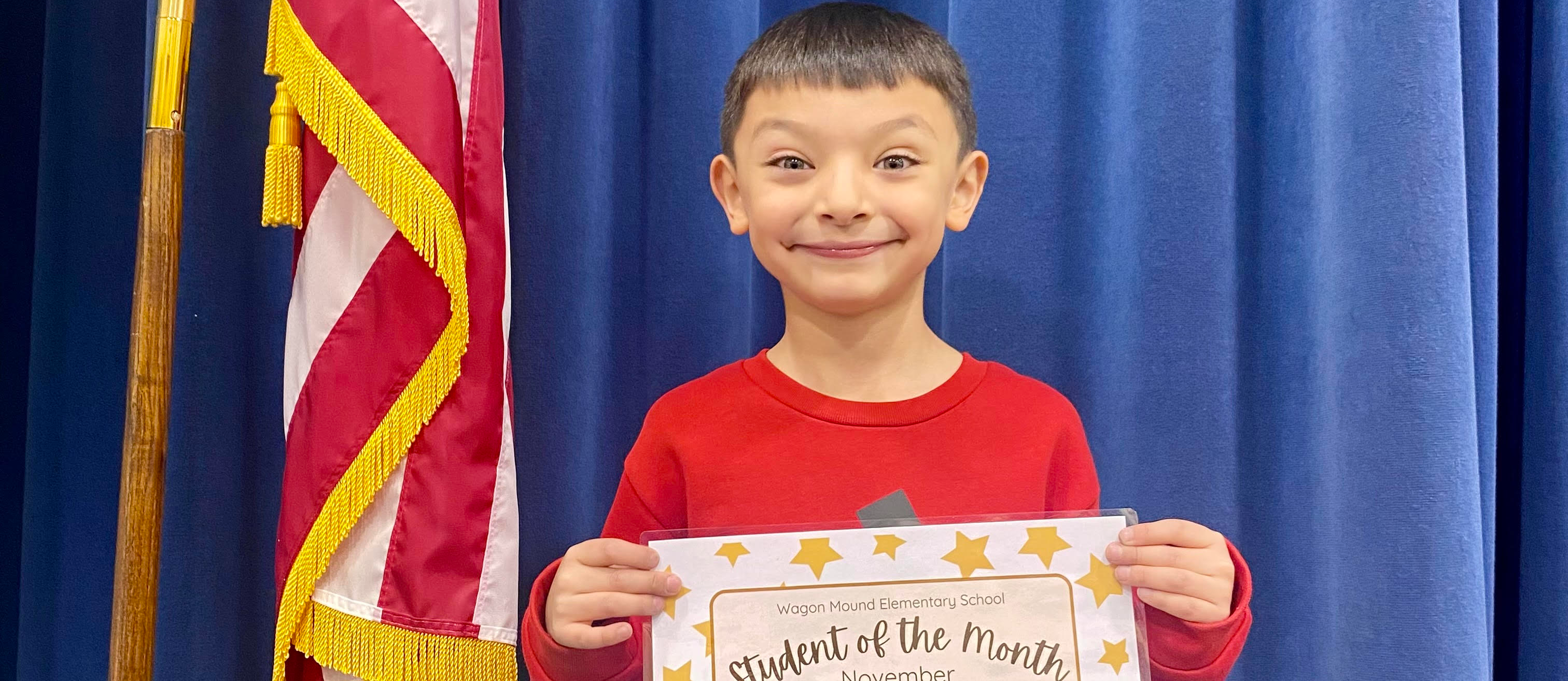 Student holding certificate, US Flag & blue background