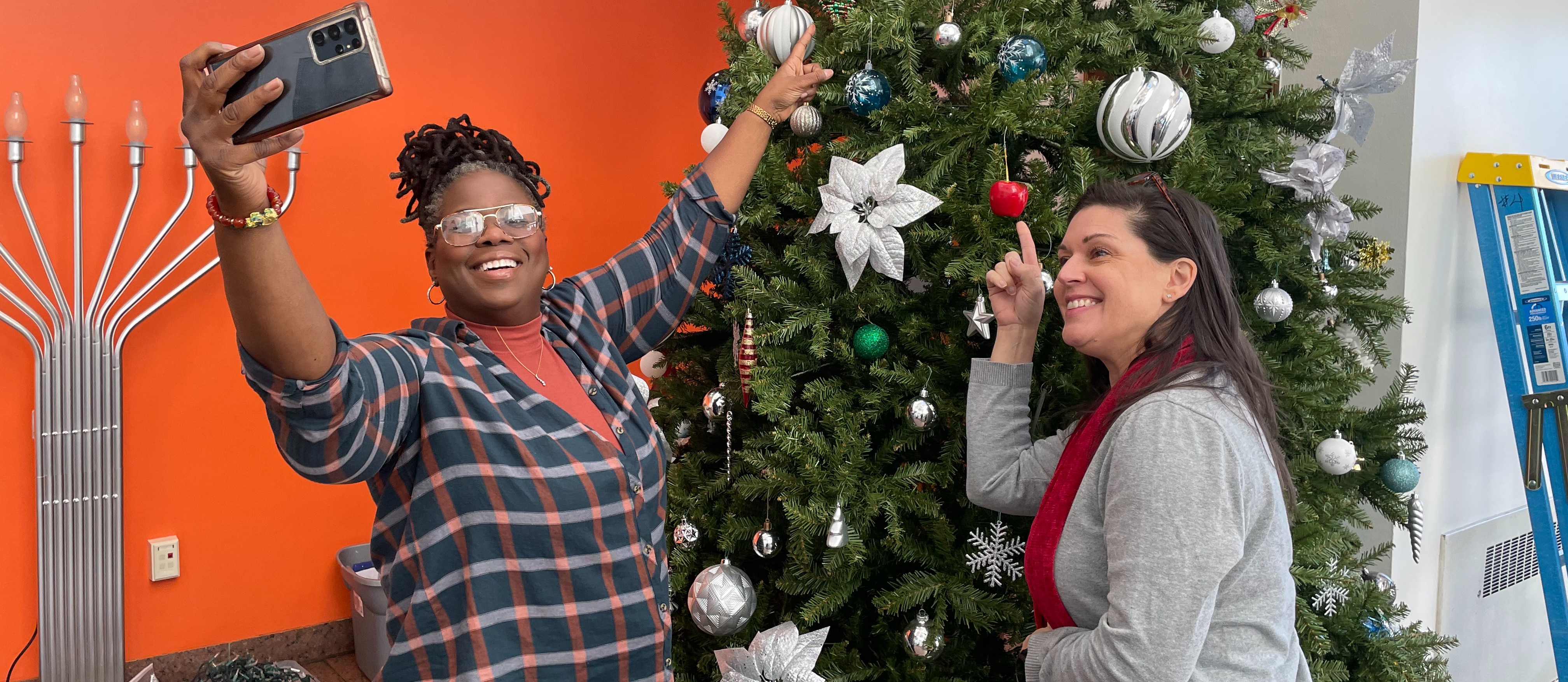 Staff decorates a Christmas tree in the North Avenue lobby