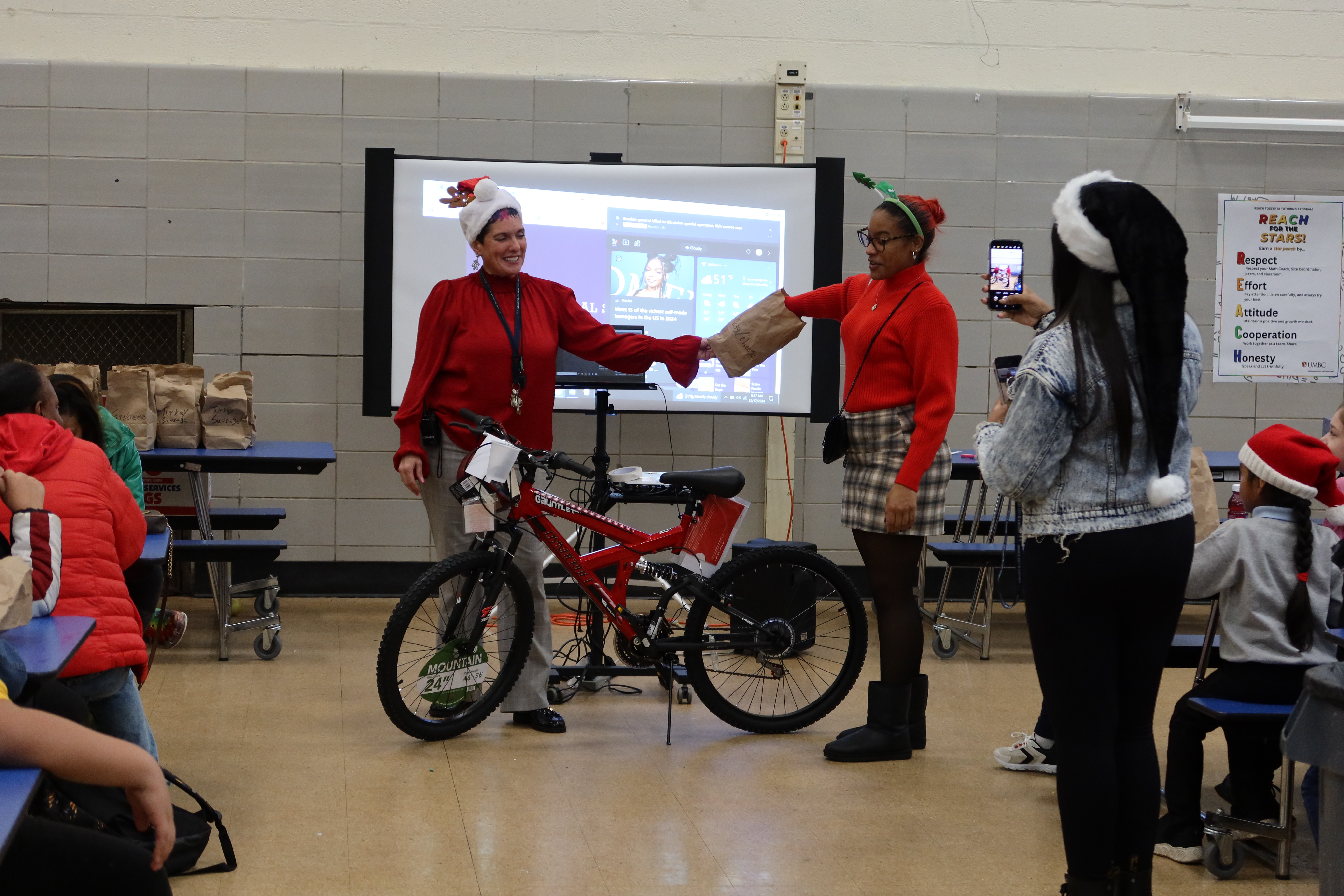 Fallstaff Staff draws a raffle ticket for a bike giveaway at the school. 