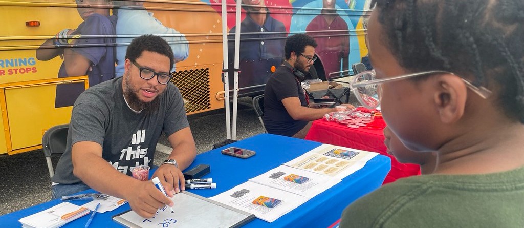 Staff member talking to students at National Night Out
