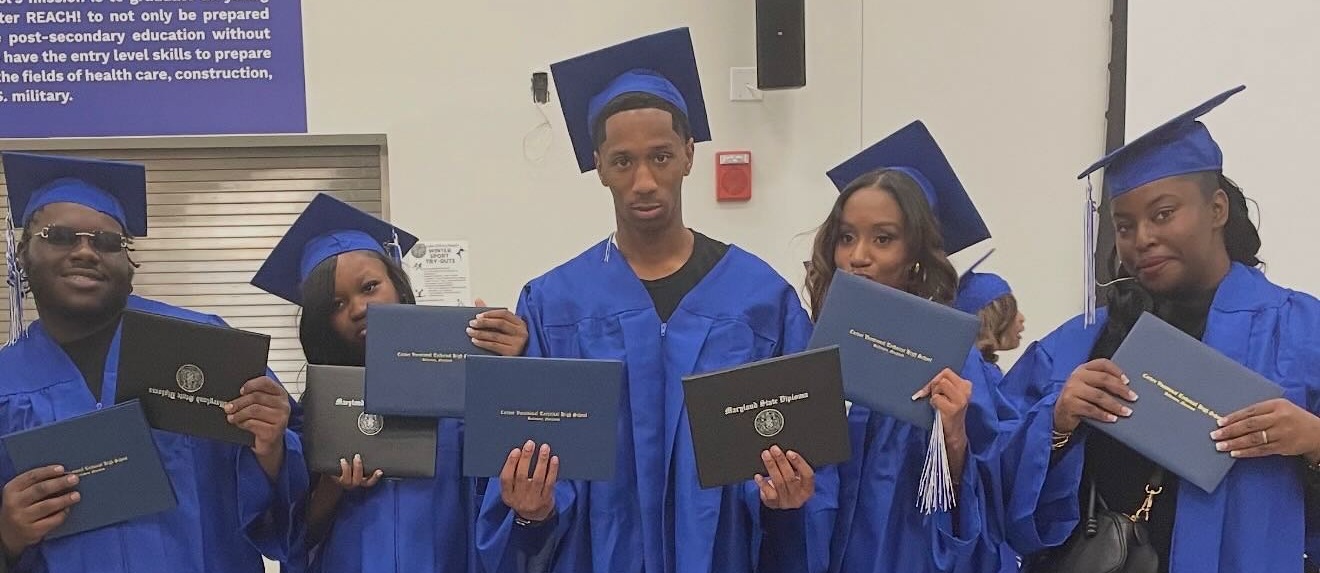 Winter graduates posing with their diplomas
