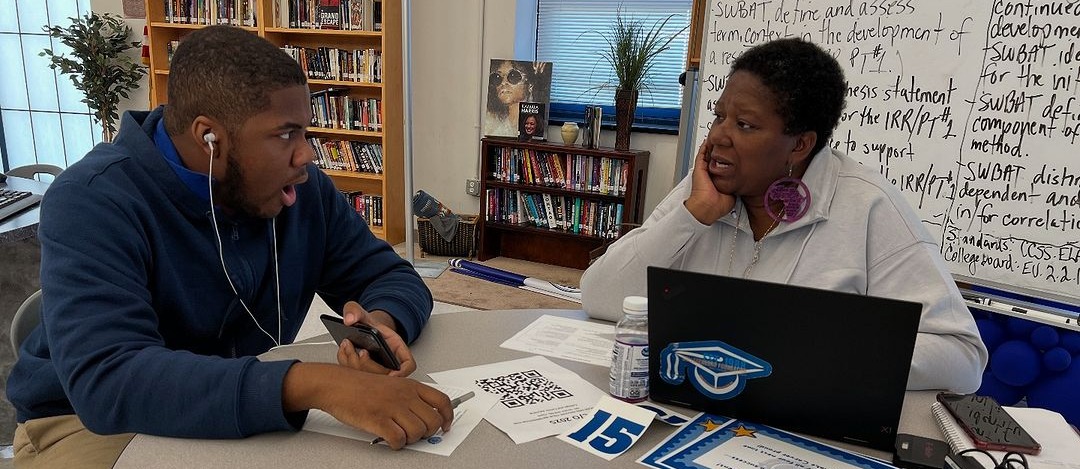 School counselor with student talking at a table