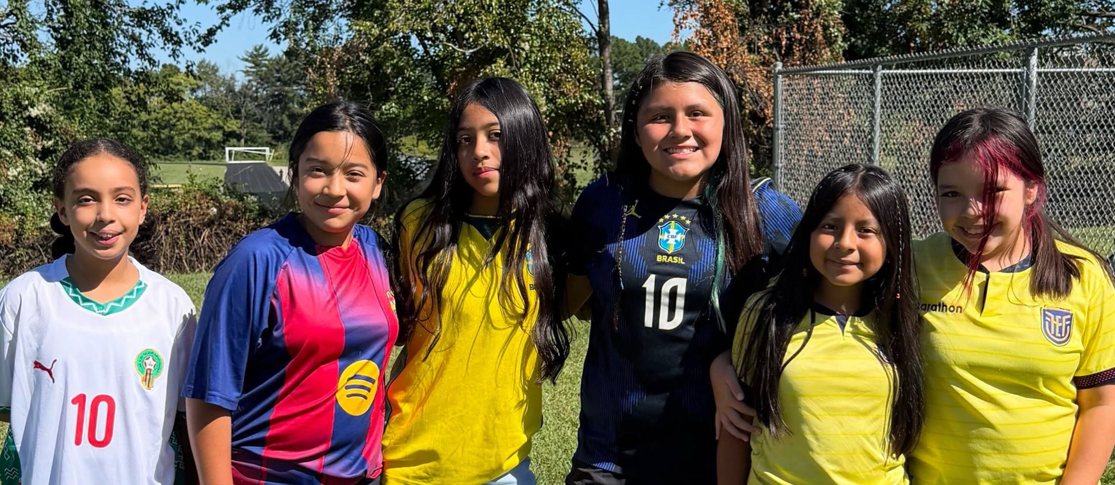 Students standing in a field posing for the camera