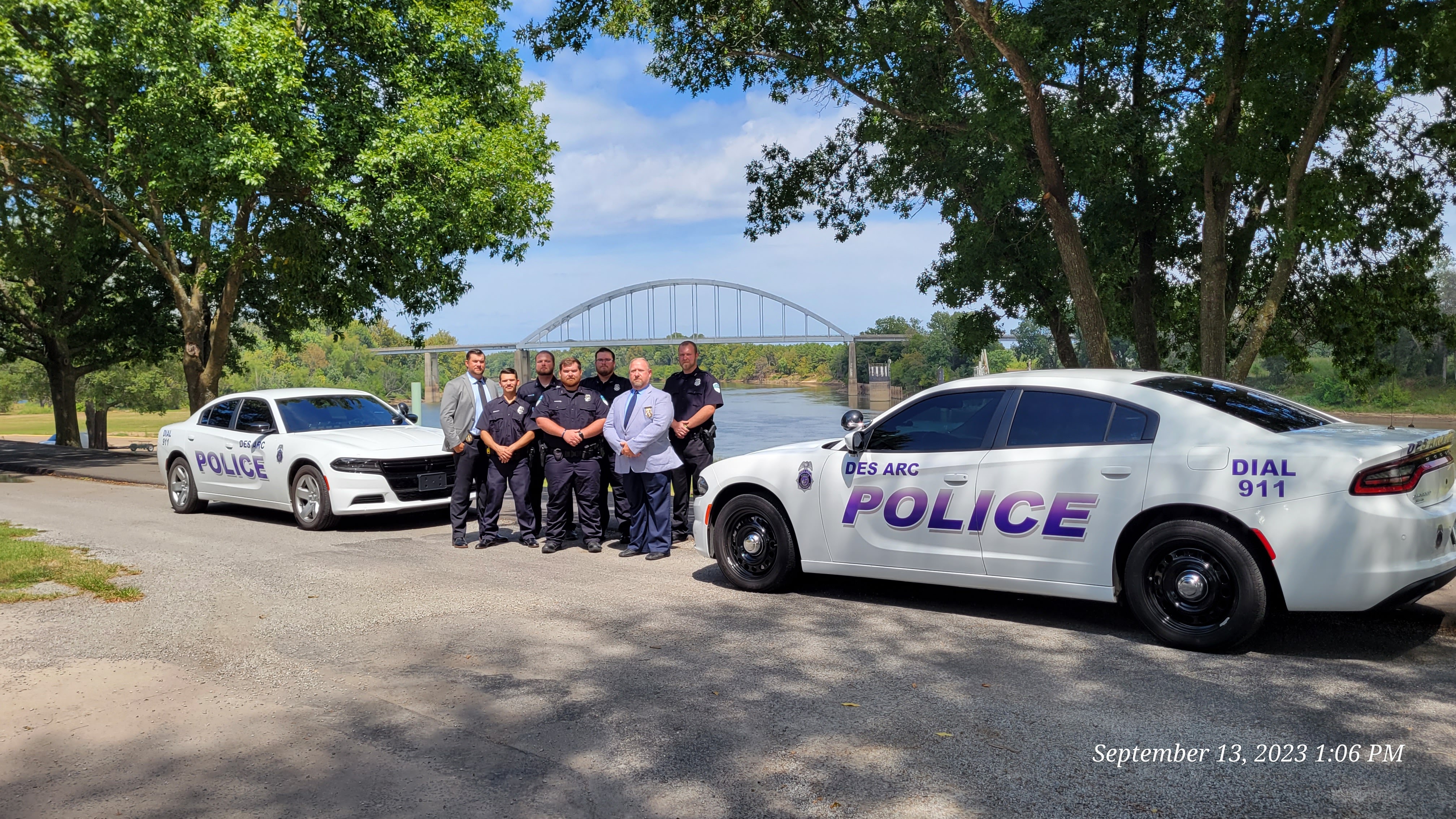 police officers in front of cars at riverfront