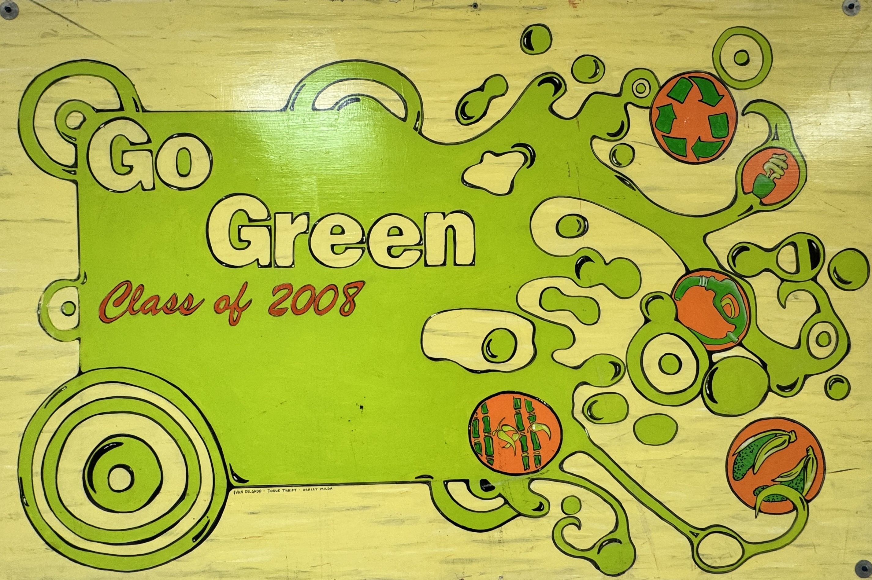 A mural with a bright green and yellow abstract design featuring circular patterns and eco-themed illustrations, including recycling arrows, a compact fluorescent light bulb, bamboo, vegetables, and a reusable shopping bag. In large bold letters, it reads "Go Green" and underneath in red script, "Class of 2008." The design is stylized with a flowing, organic pattern spreading across the right side of the mural.