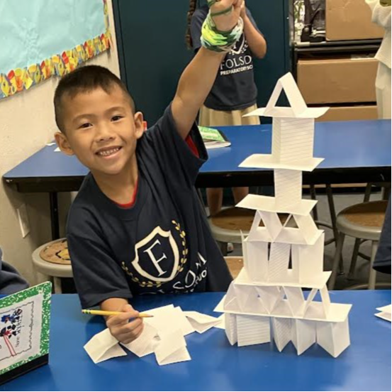 A student showing off a tower made of index cards