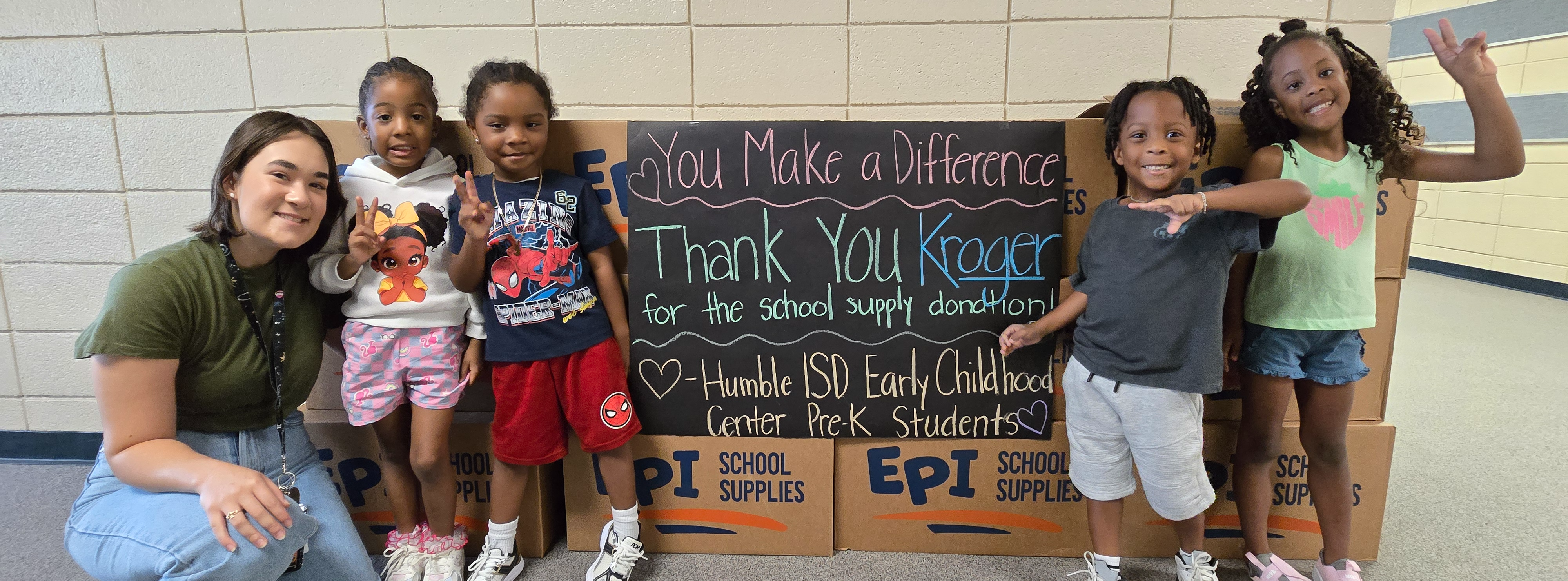 Social Skills Support/PFL Nina Datz and  Pre-K students from Mrs. Norton's class smile with school supplies donated by Kroger.