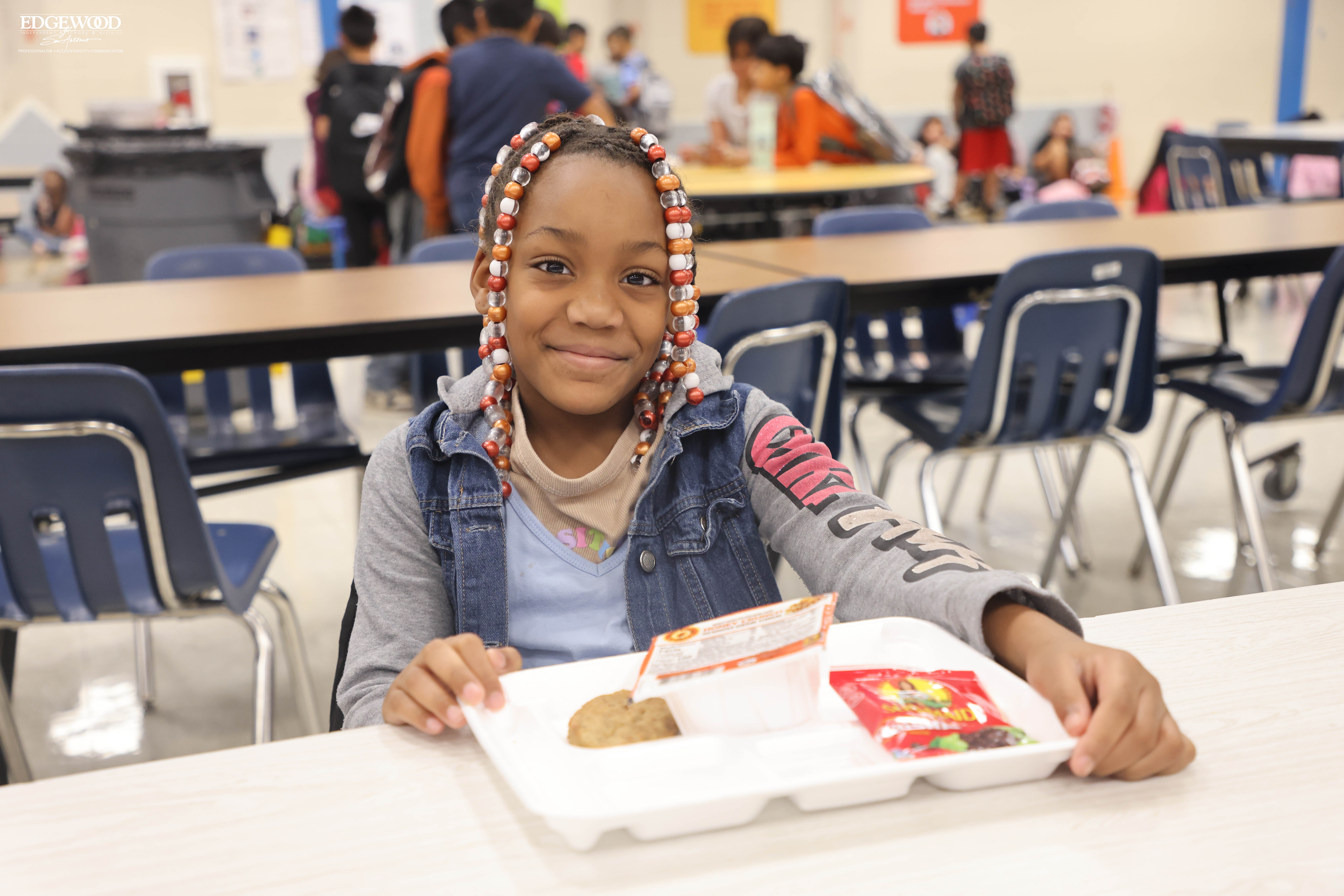 Female student enjoys breakfast at LBJ Elementary