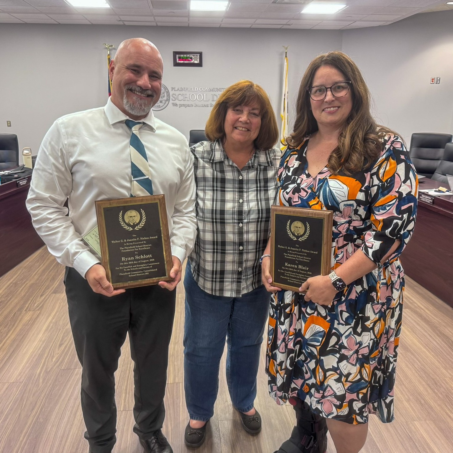 ryan schlott, margie bonuchi and karen blair stand in boardroom 