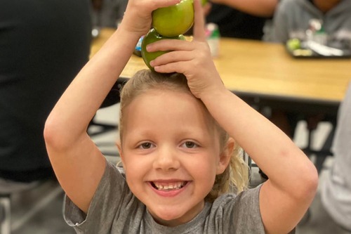 girl balancing apples on her head