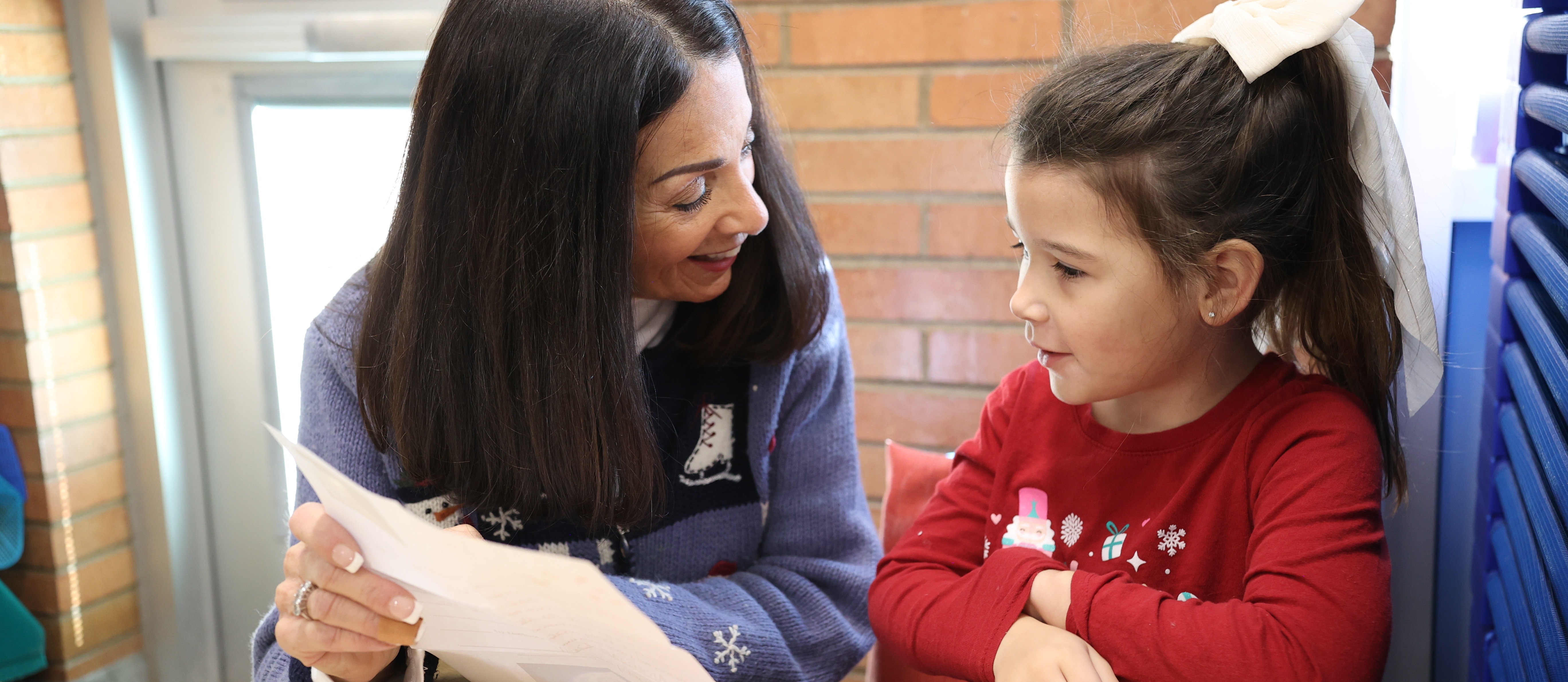 Ms. Shauna reading a Santa Letter to a PreK Student.