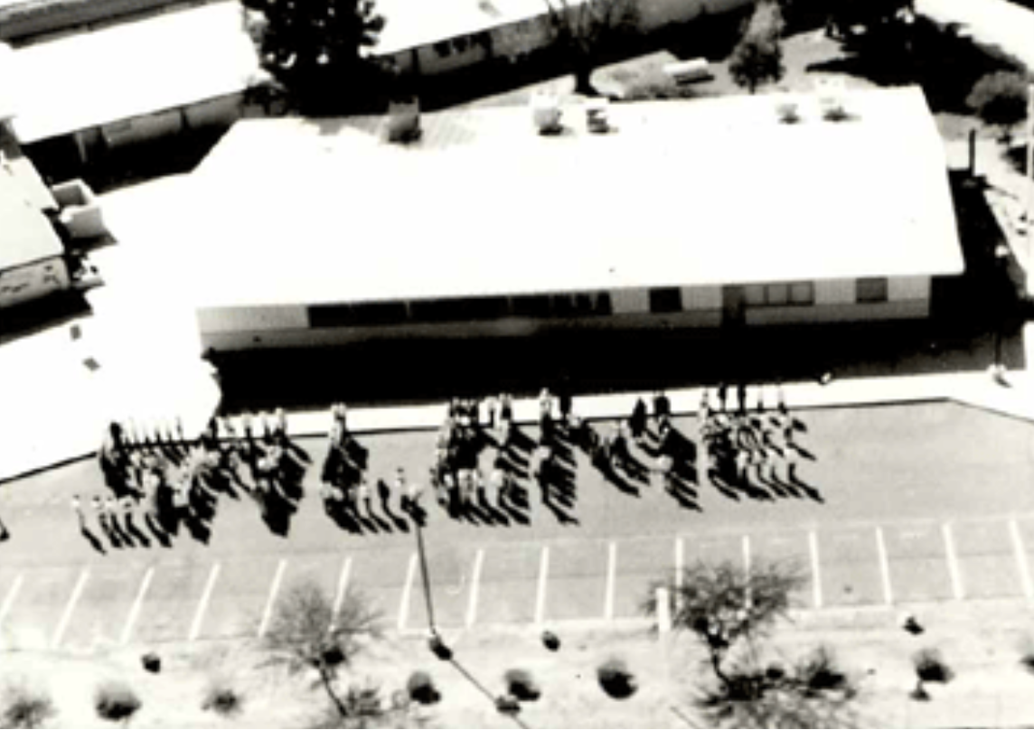 Aerial view of students forming the letters "Salome" next to the building