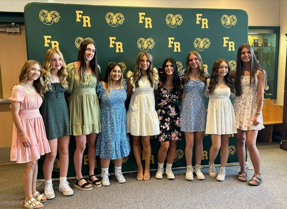 8 female students pictured together in front of flat rock green and gold backdrop