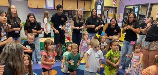 Preschool and high school students watching a video