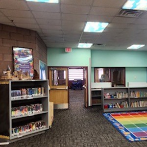 Library shelves and color block rug sitting area