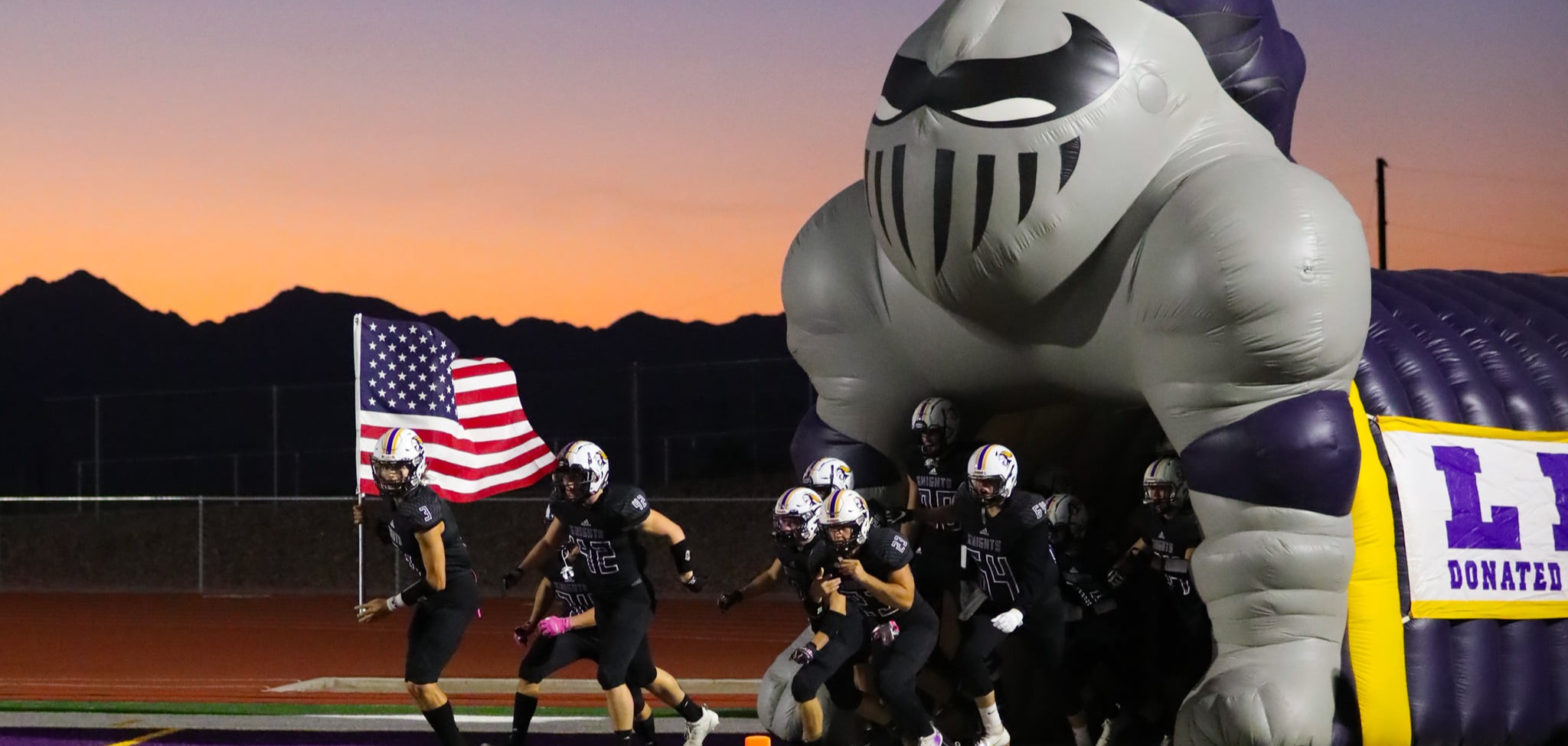 LHHS football players running out of the Knights tunnel