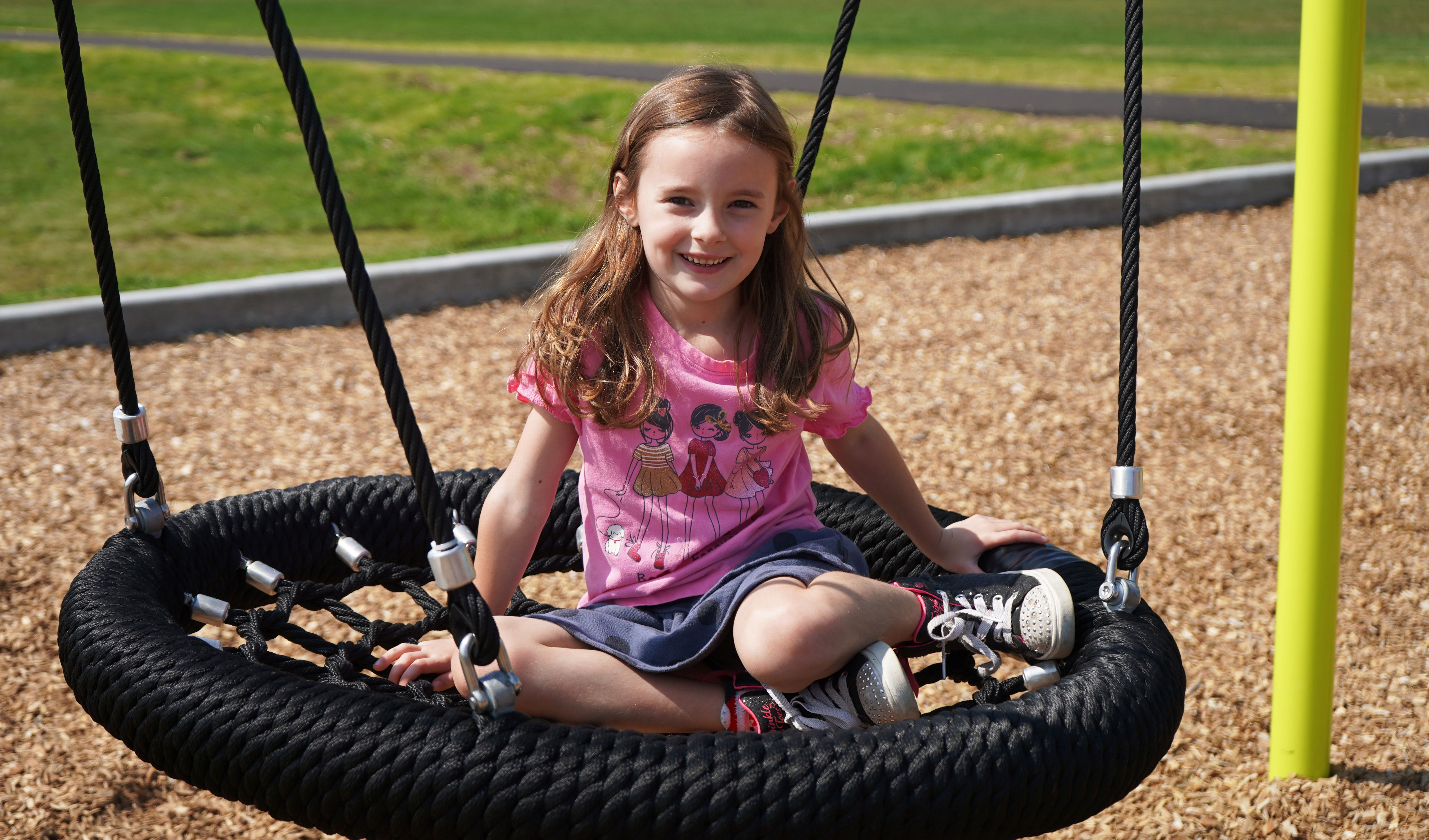 Student sits on playground swing.