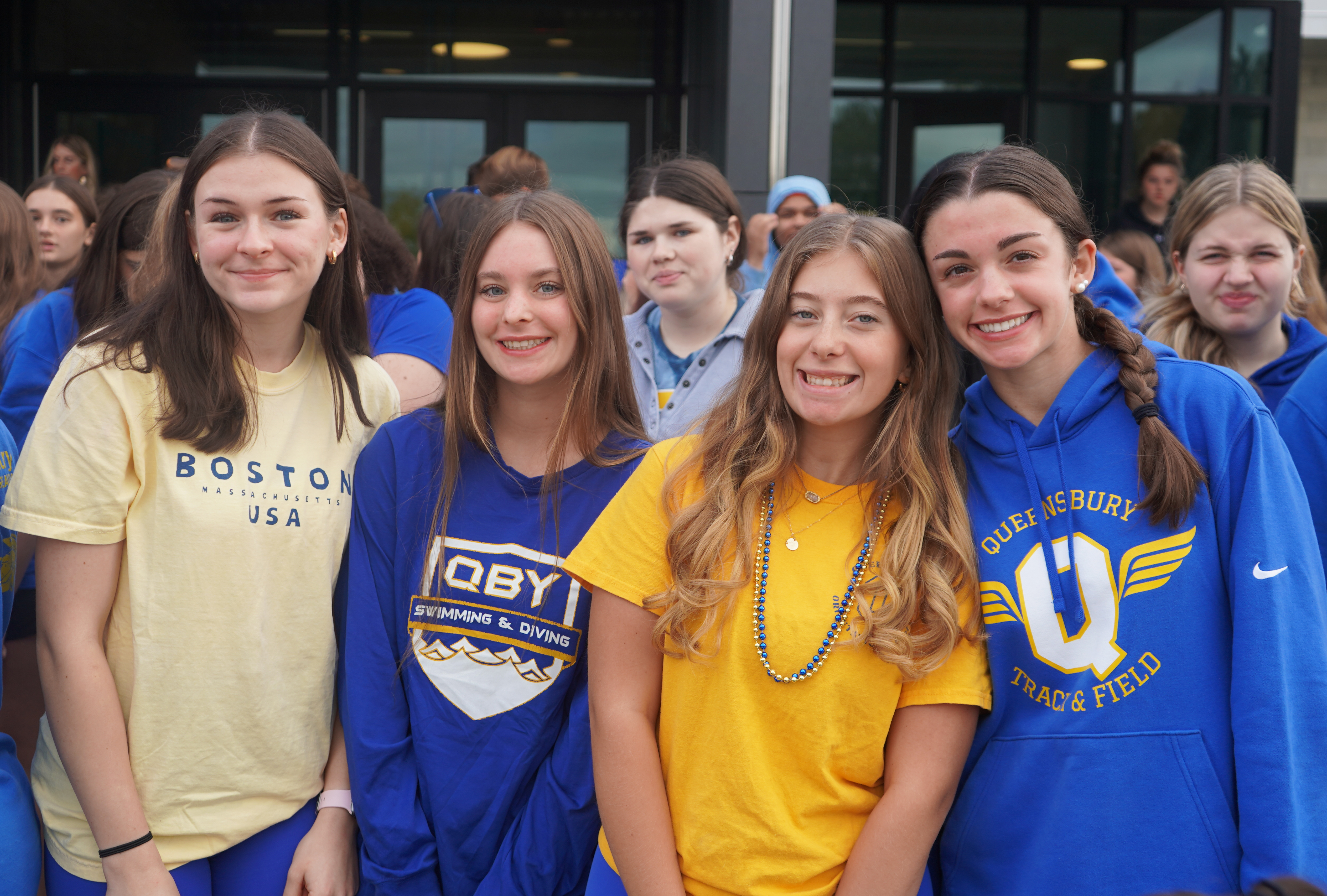 Students stand in front of high school.