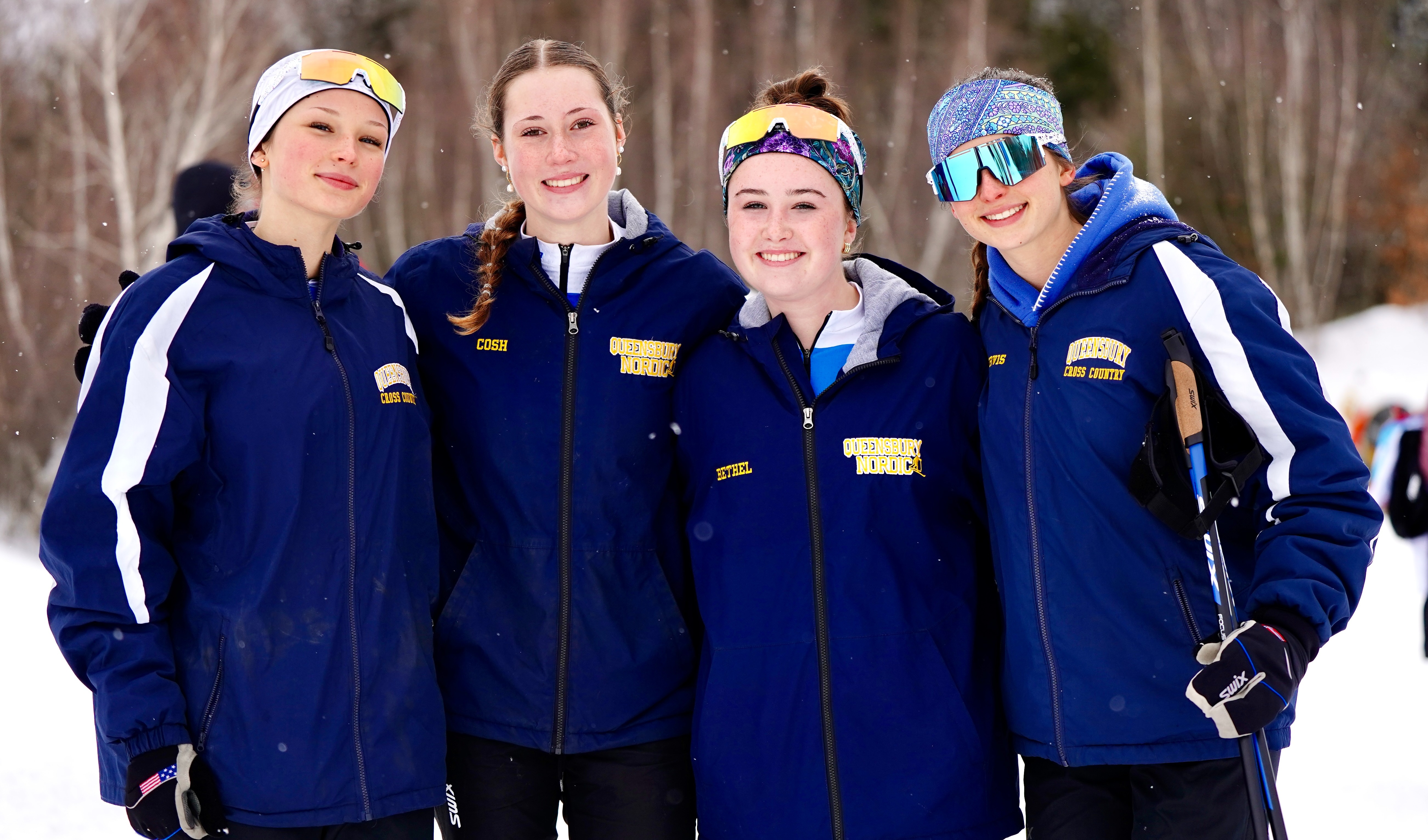Four Nordic ski athletes stand together for a photo.