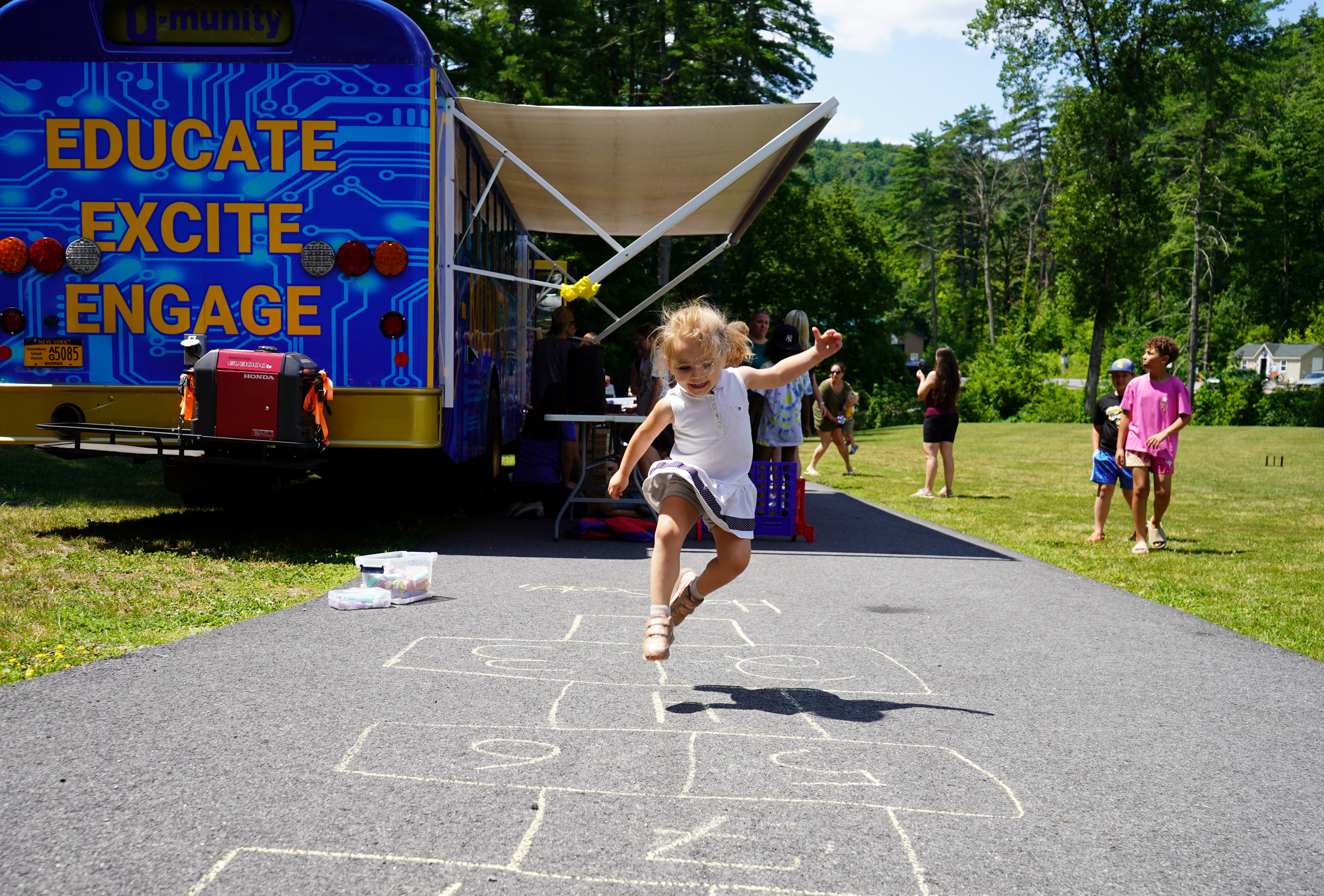 Young girl plays hop scotch.