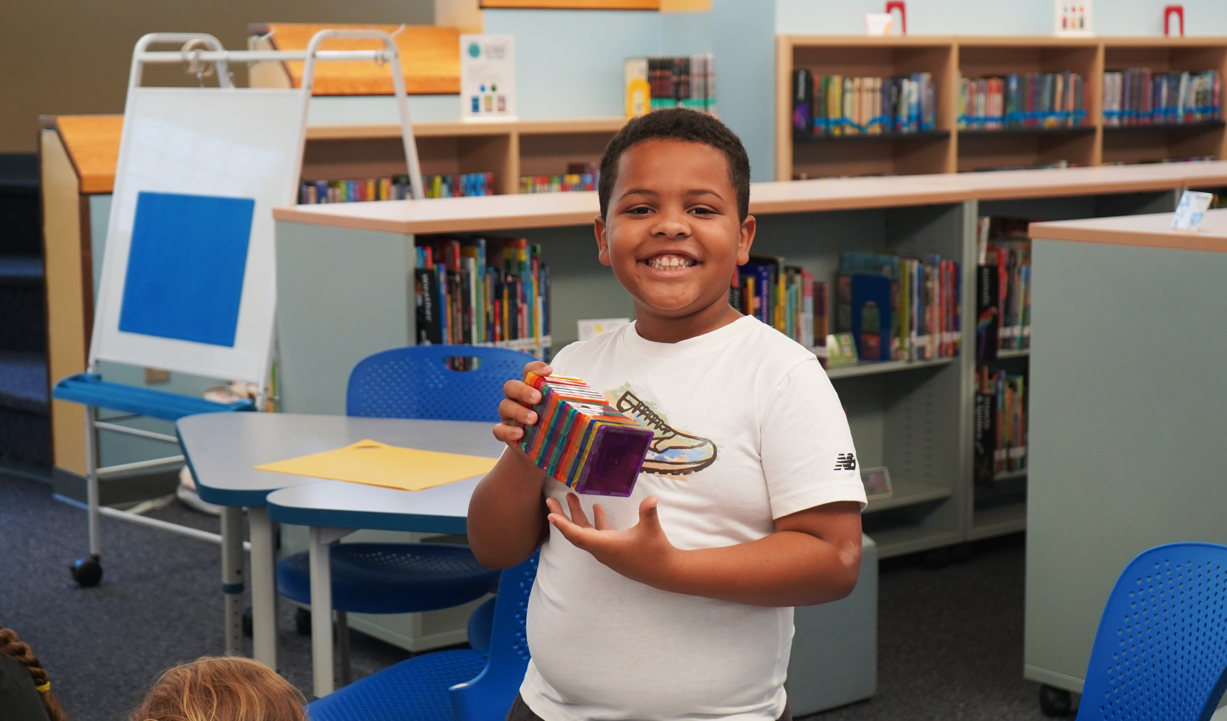 Student stands in school library during Summer Academy.