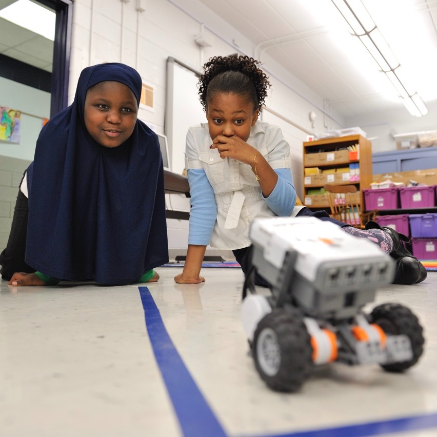 Two students using lego robot in class