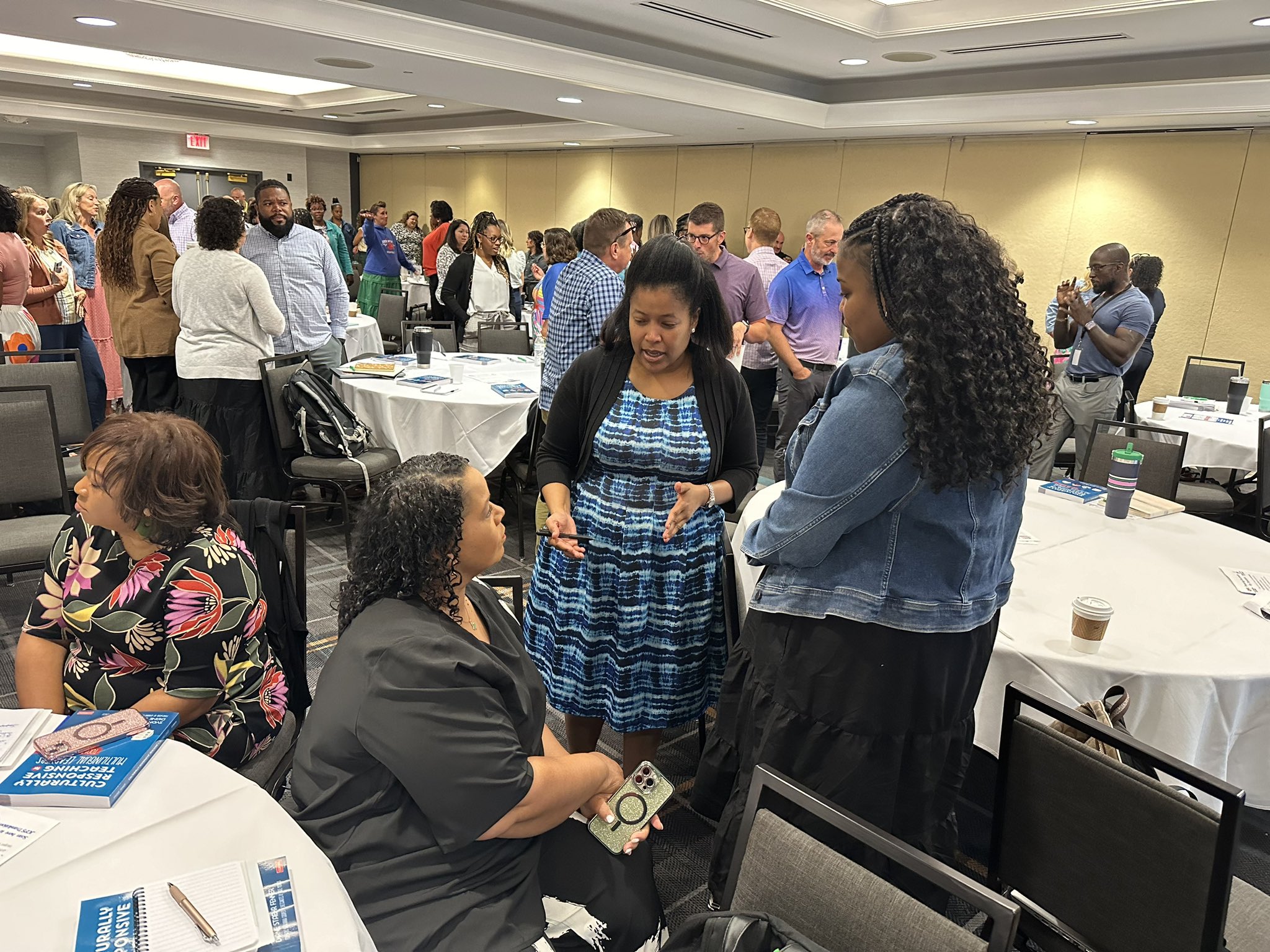 group assistant principals standing around sharing out ideas at a conference