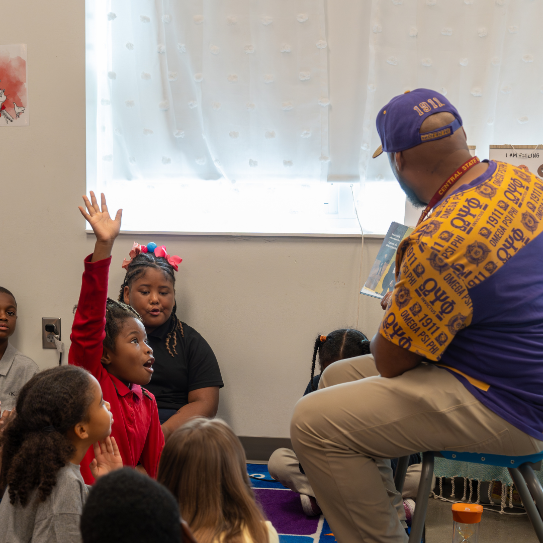 Man reading book to students