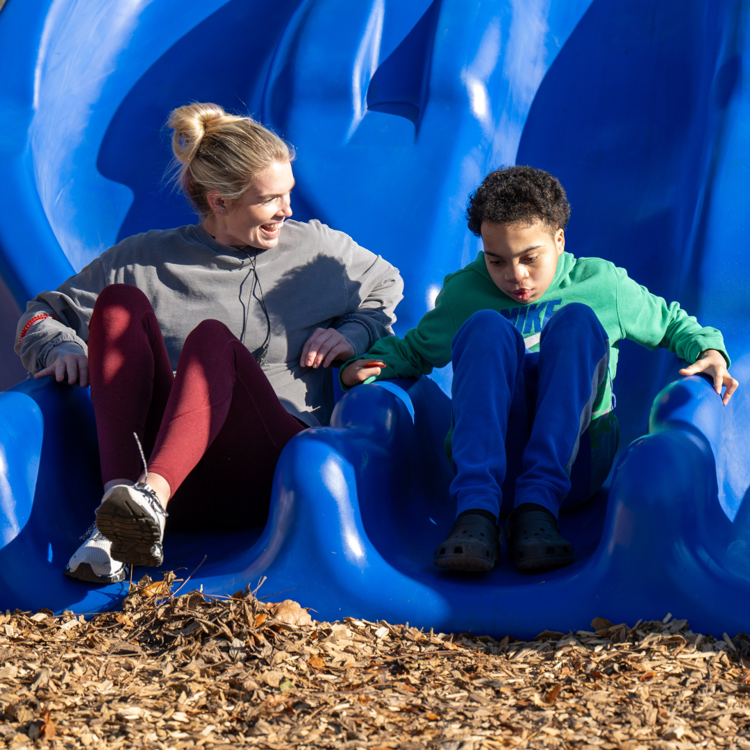 Woman and child sliding down slide