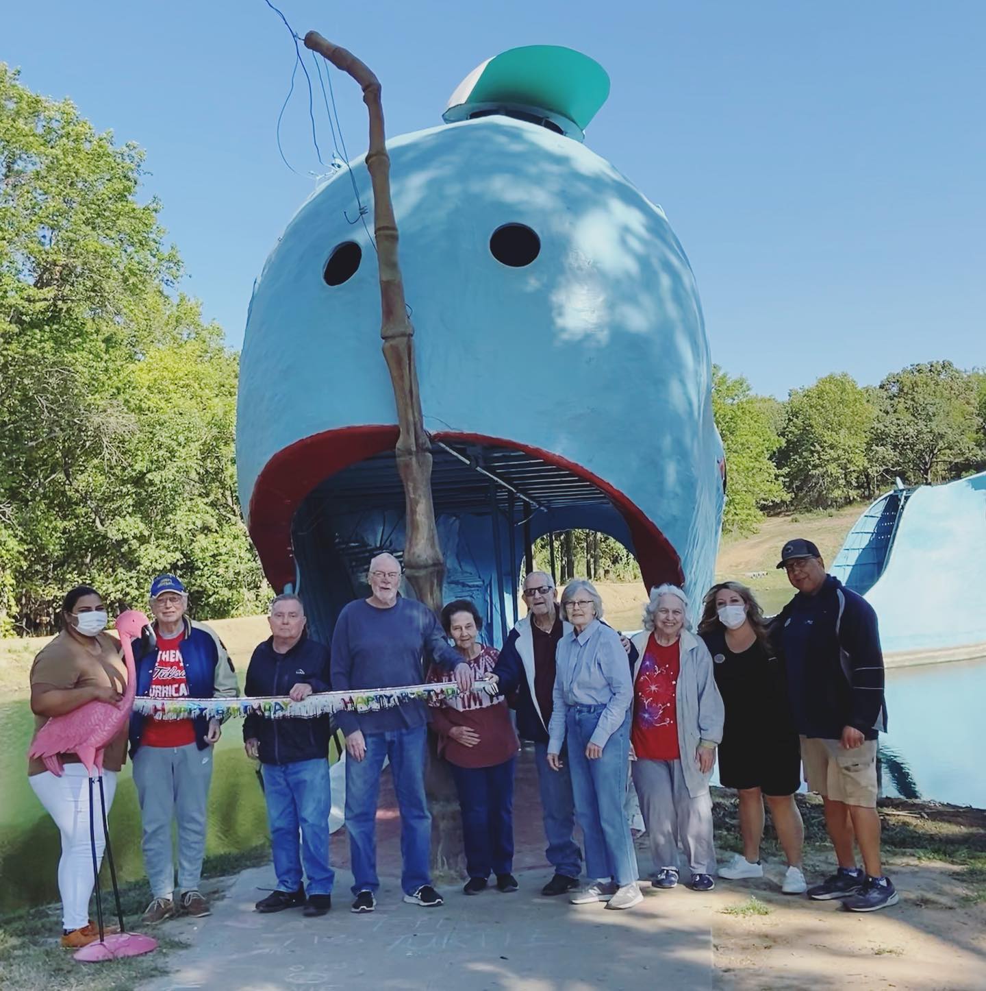 family in front of blue whale