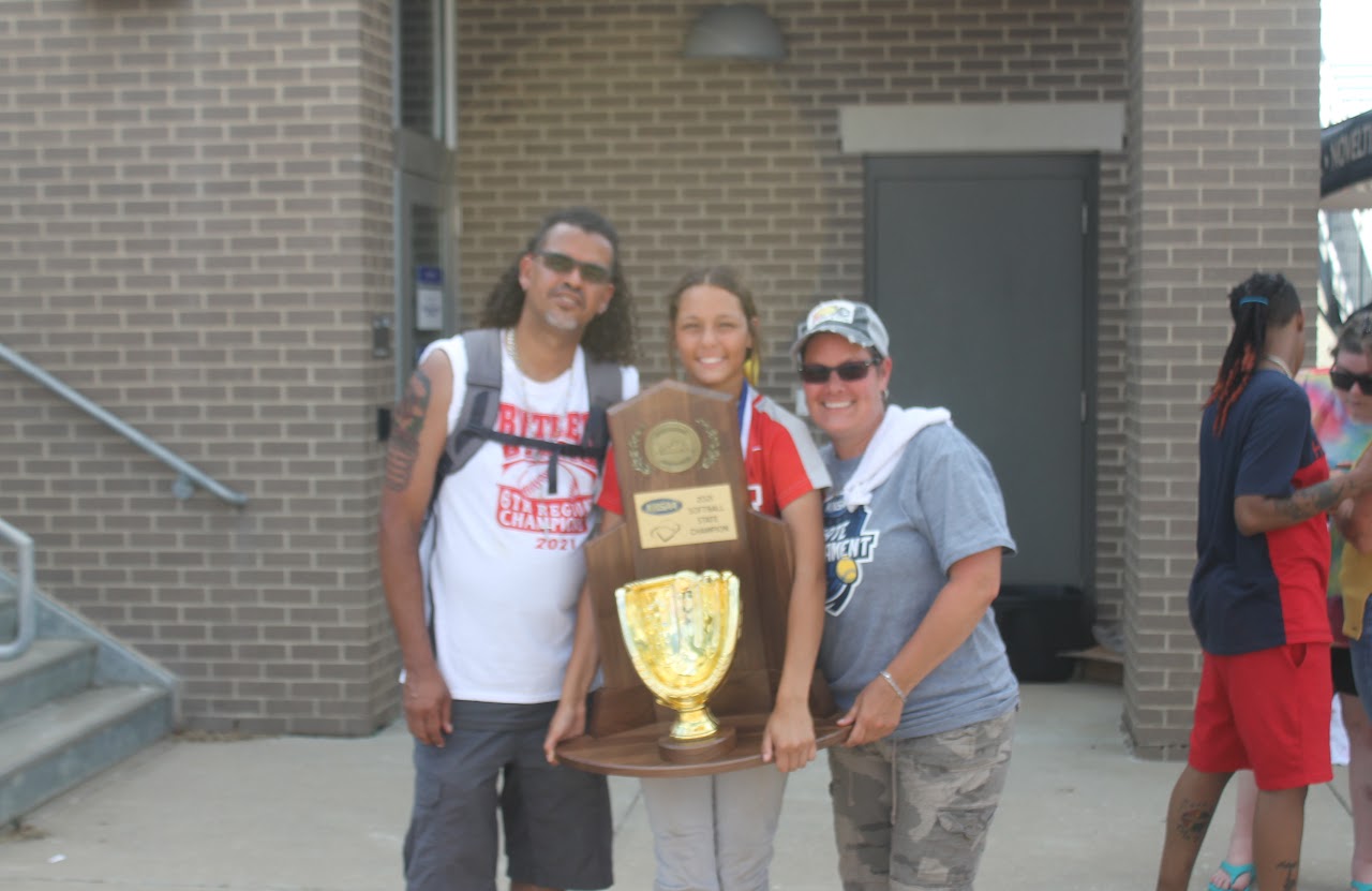 Congratulations to the winning team! They are posing with their trophies and sports equipment, celebrating a successful season.