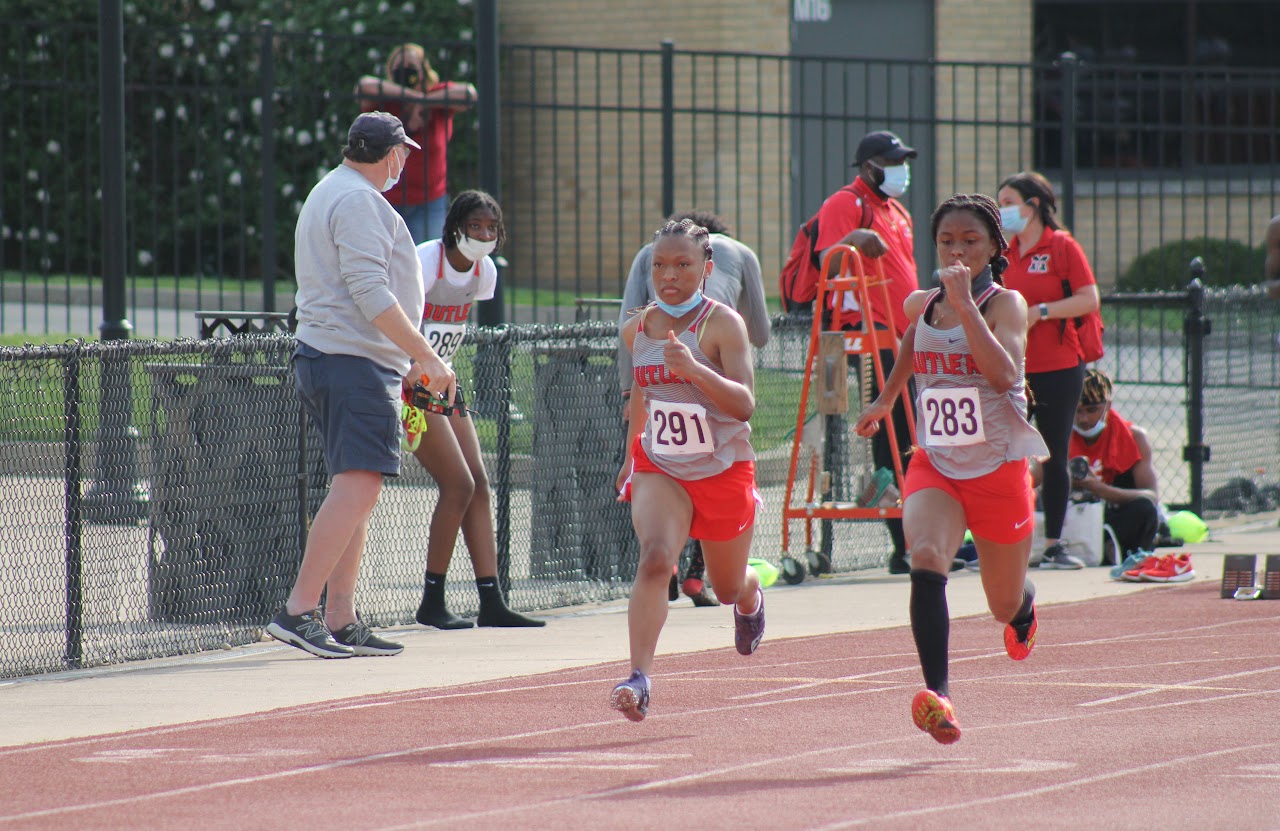 students running and coaches watching