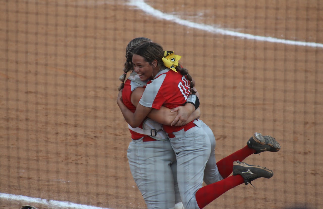 baseball team members hugging after a victory