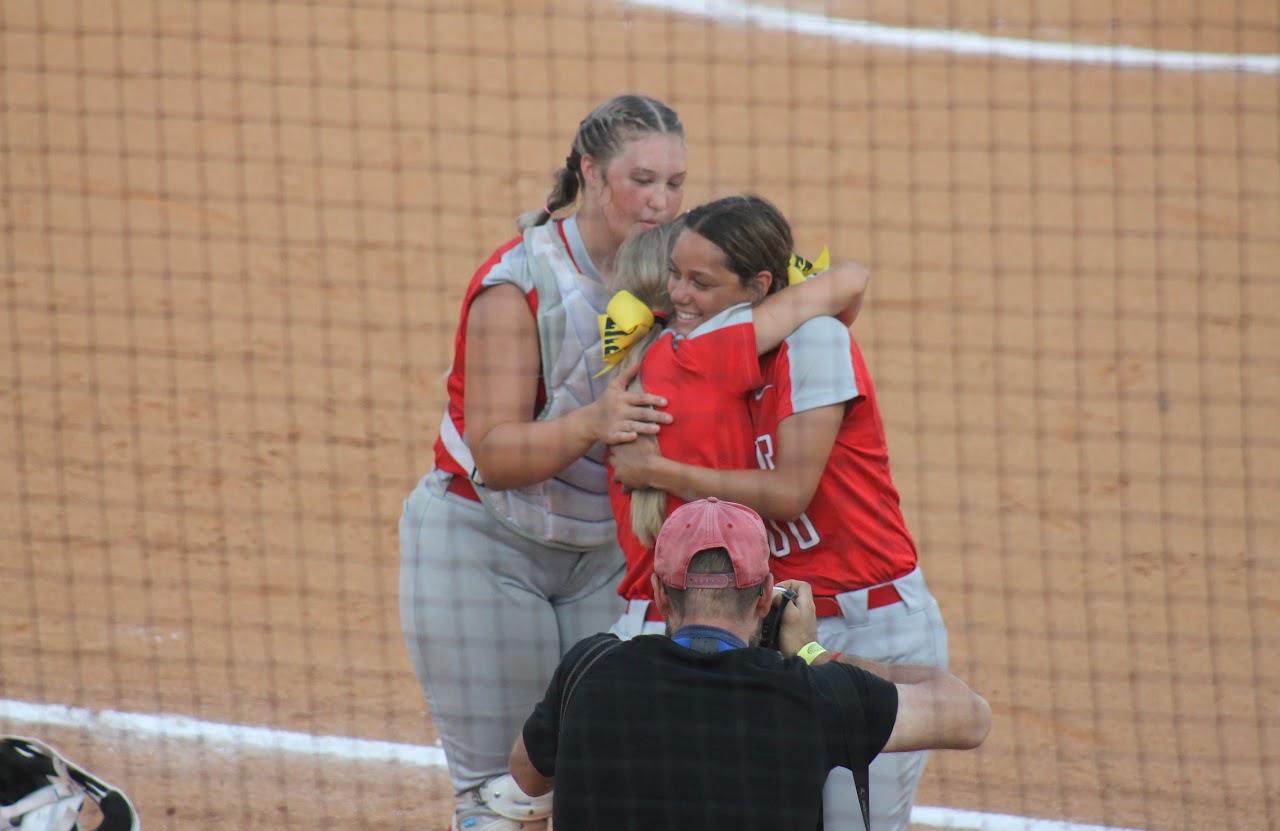 baseball team members hugging after a victory