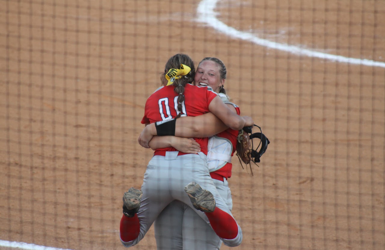 baseball team members hugging after a victory