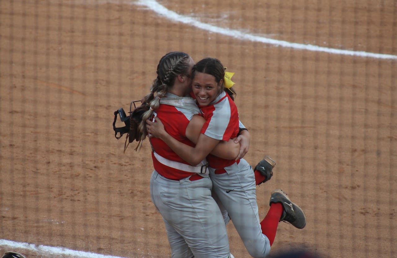 baseball team members hugging after a victory