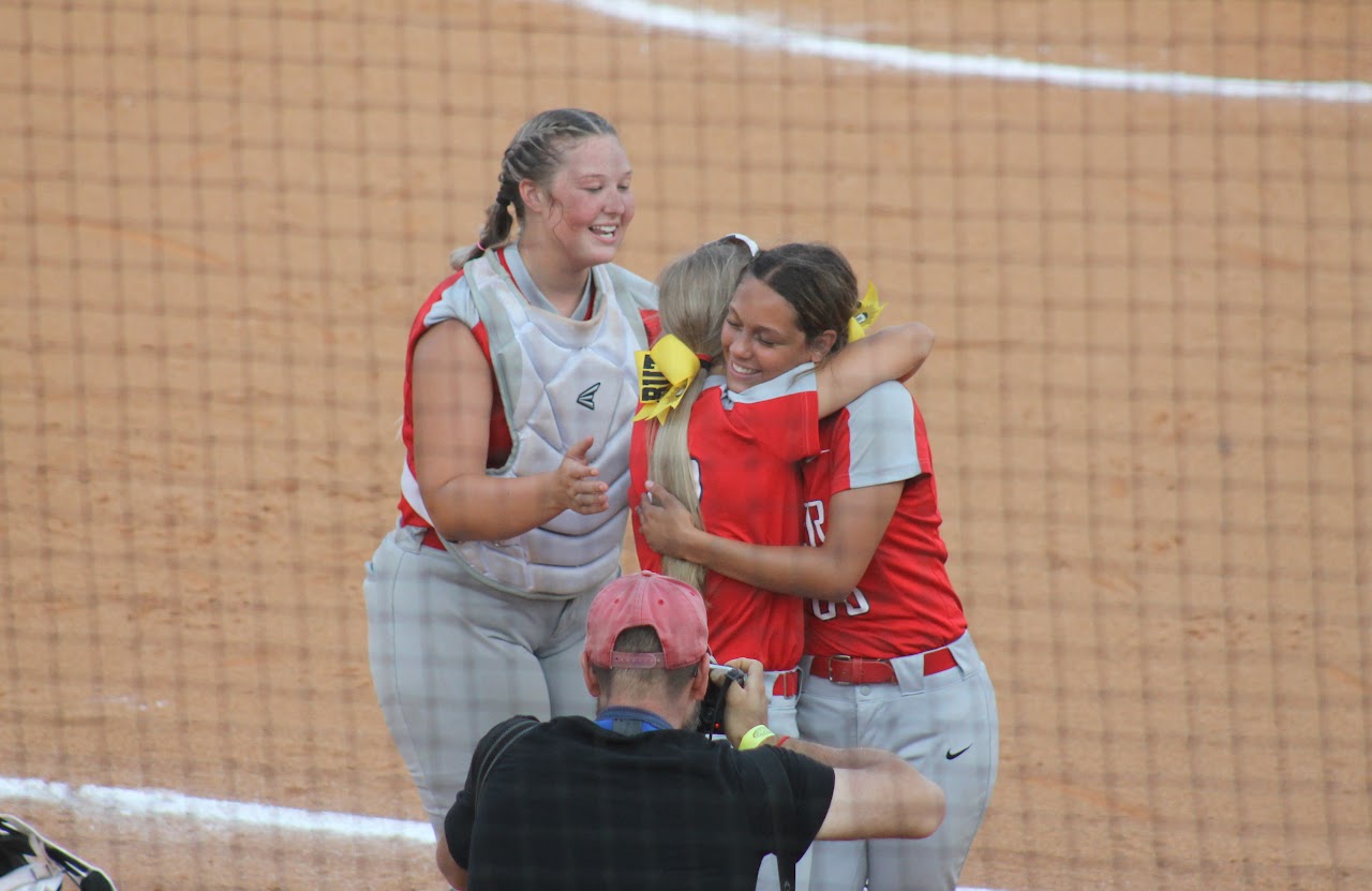 baseball team members hugging after a victory