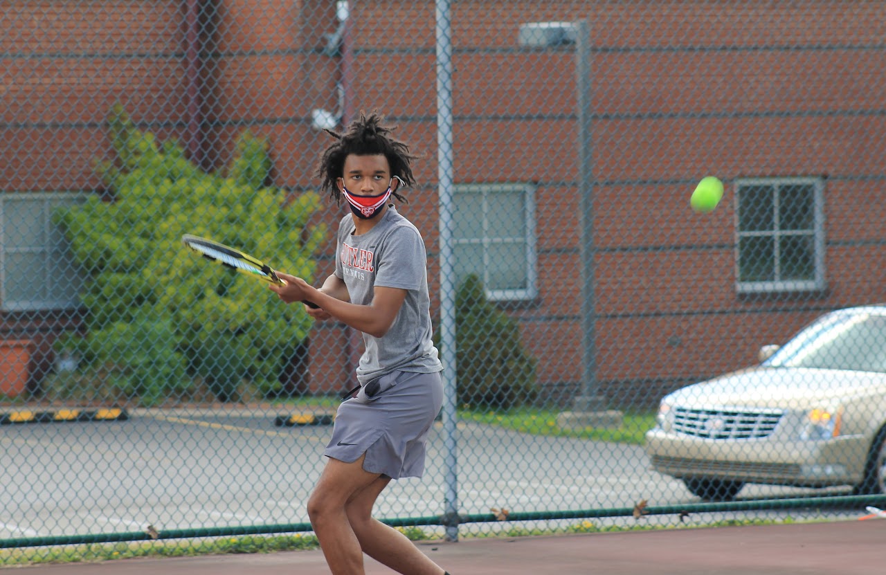 player about to hit the ball and wearing facemask