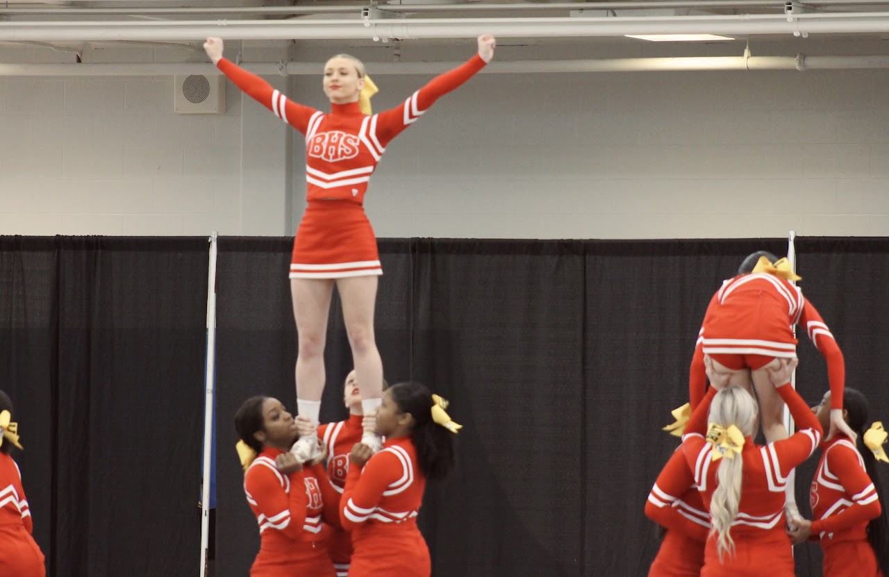 Cheerleader with open arms being carried 