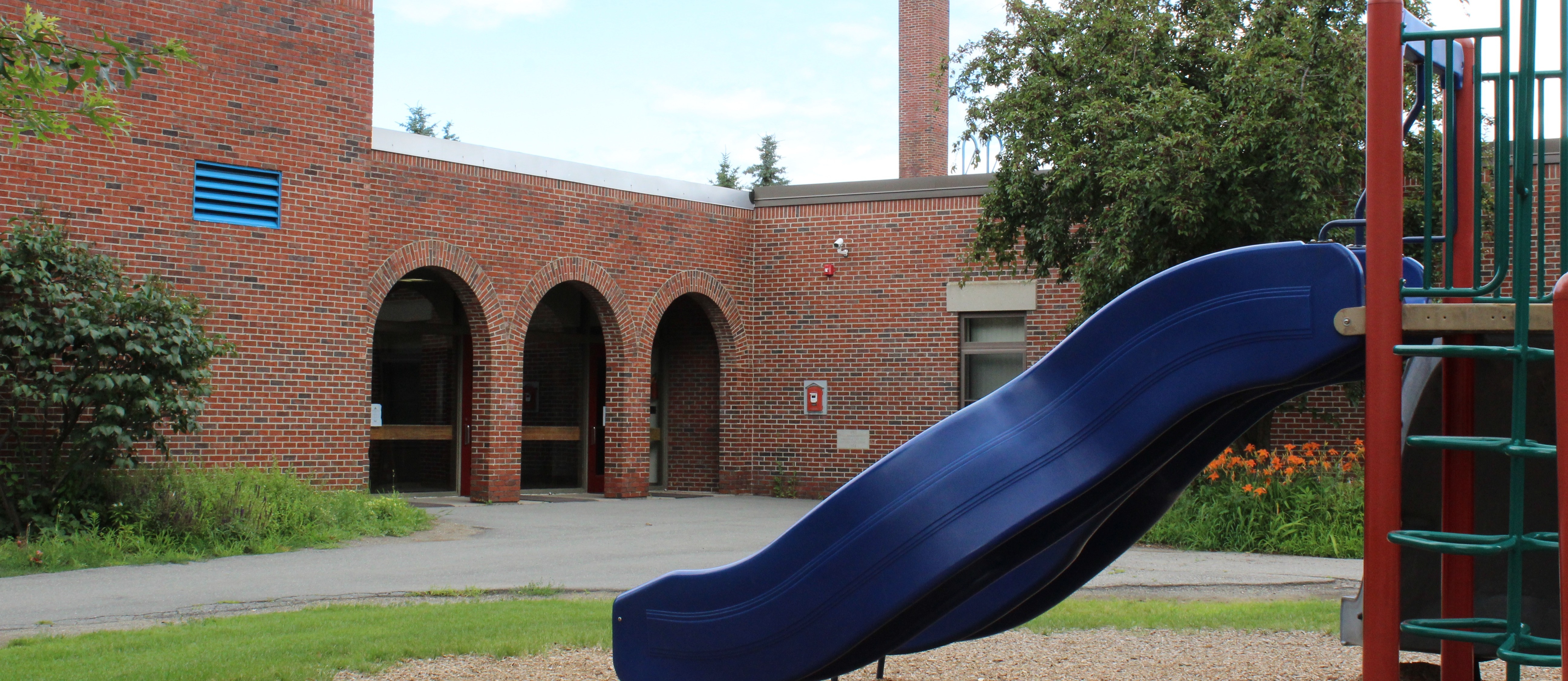 front of Abraham Lincoln School. Blue slide with arches ofthe school in the back ground