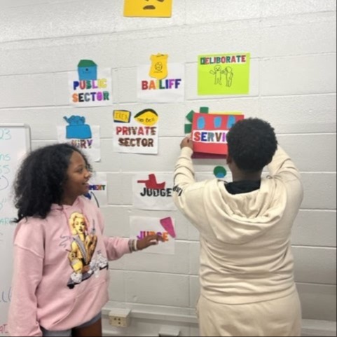 Students putting up pictures in the classroom