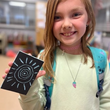 girl showing notebook and smiling