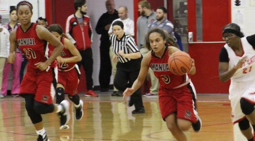 Female basketball players in uniforms in mid-action during a game.