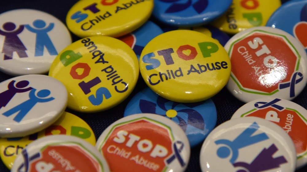 A collection of colorful buttons advocating for child abuse awareness and prevention.