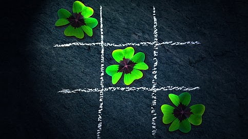 A four-leaf clover crossword puzzle with shamrock pieces, against a dark background.