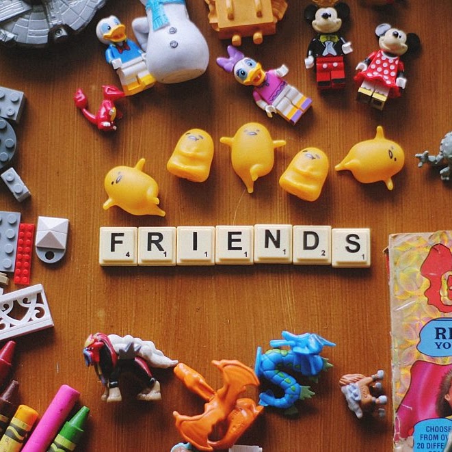 A colorful display of toys with the word 'friends' spelled out using Scrabble tiles.
