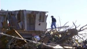 This is a photo of a man on the second story of his destroyed home after a tornado hit Battlefield in 2003.