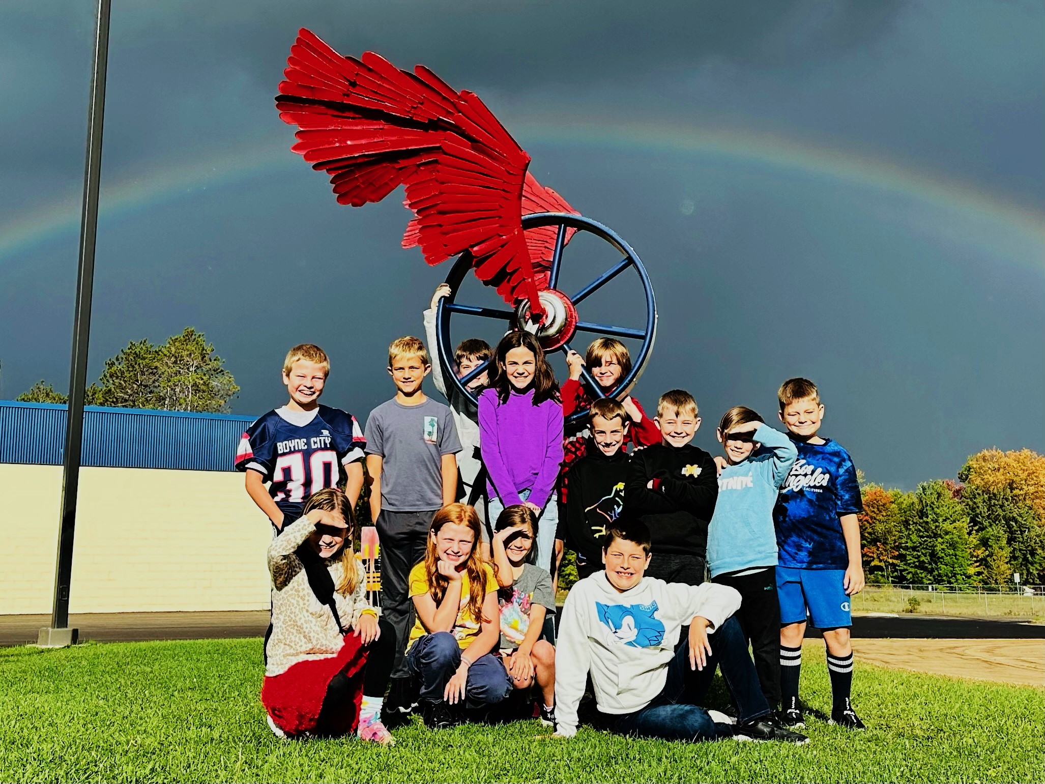 One of the 4th Grade Classrooms posing in front of a rainbow