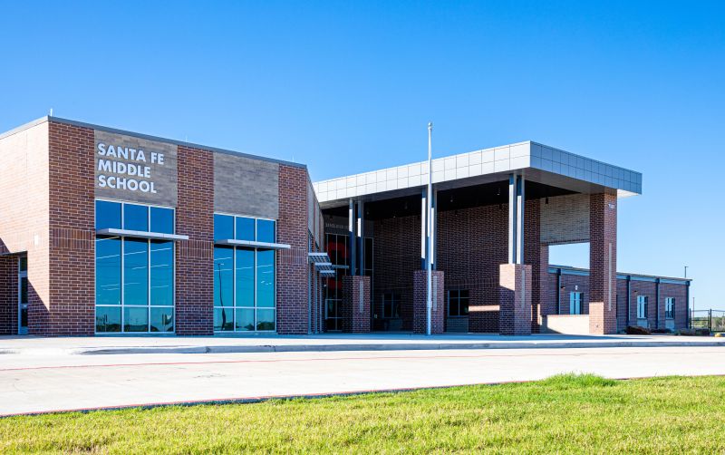 Large, modern building with a brick facade and large windows. "Santa Fe Middle School" is on the wall.