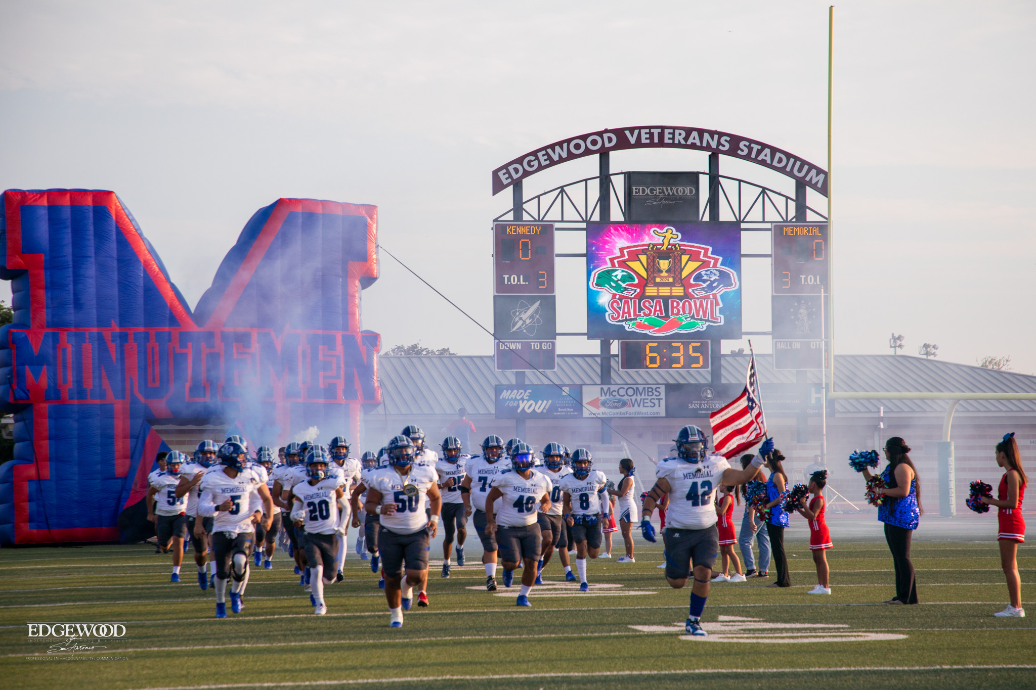 Football team runs onto the field in a cloud of smoke